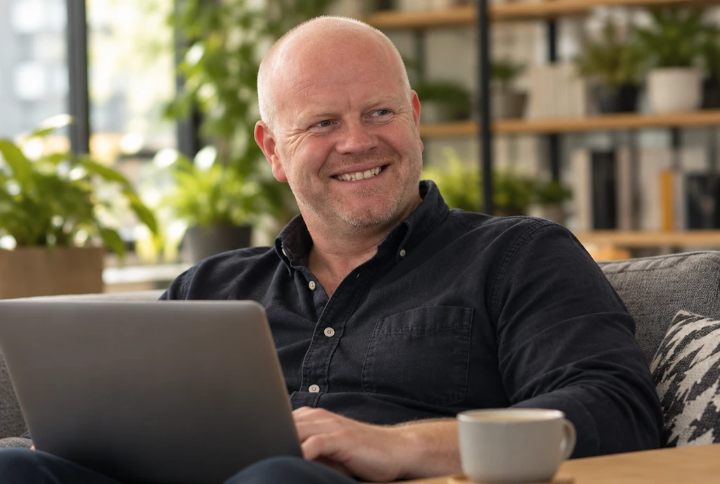 Marc De Bock van mBoost met een laptop en een kop koffie, klaar voor een online gesprek.